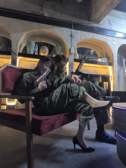 迷彩服を着た男女がハンドガンを持ち決めポーズ