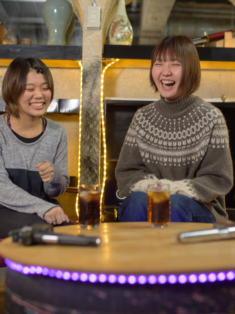 女性二人が酒を飲みながら楽しそうに談笑している様子