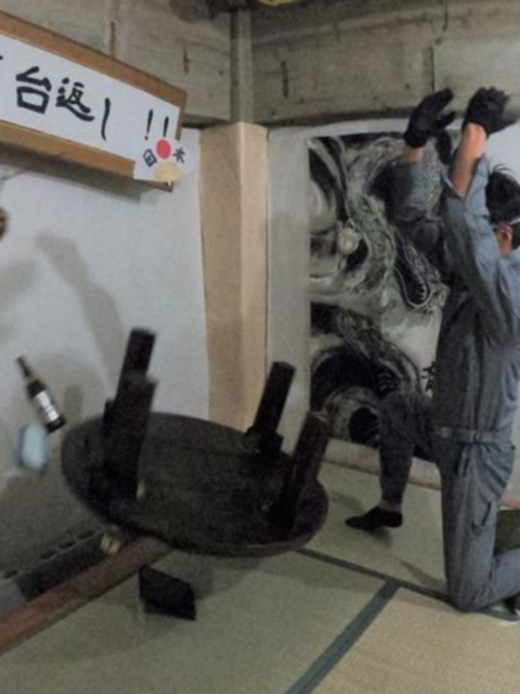 酔っぱらった男性がちゃぶ台を豪快にひっくり返してる様子