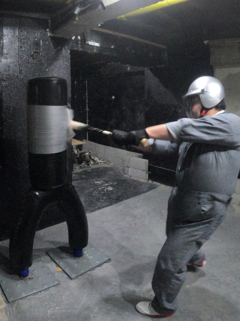 男性がバットでサンドバックを激しく叩く