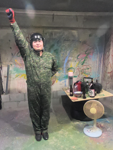 破壊部屋で今から壊すものを用意し、男性一人が上を上げポーズをとってる様子。