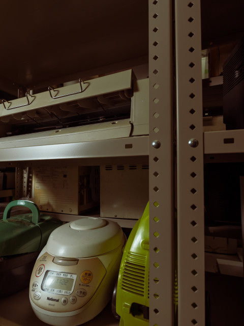 スチール棚にある、炊飯器と掃除機