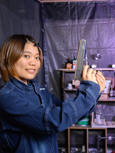 デニムの女性がU2のハンドガンを持ち決めポーズ