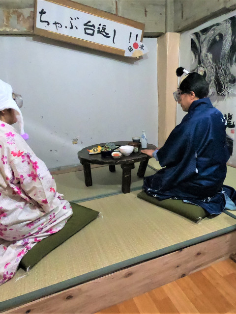 夫婦がカツラや衣装を着て、U2のちゃぶ台をひっくり返す寸前