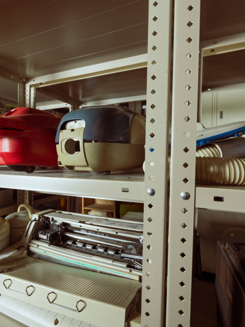 破壊体験用の掃除機・炊飯器・プリンターなどの廃棄品が並ぶU2のアイテム棚